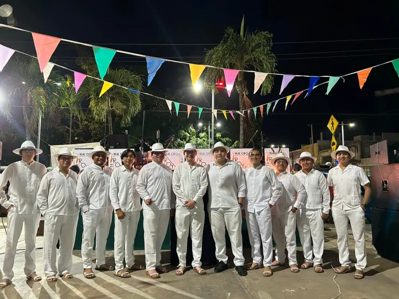 Integrantes de la orquesta de pie bajo banderines, en Chemax